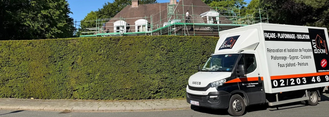 Camionnette de l'entreprise Batidom Rénove garée le long d'une haie