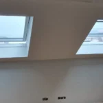 Mur plafonné autour de deux Velux dans une mansarde