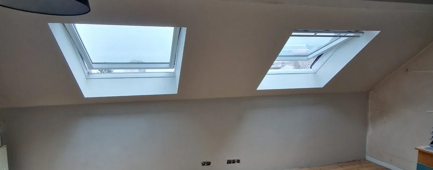 Mur plafonné autour de deux Velux dans une mansarde